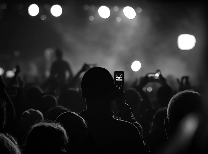 Imagem de uma plateia filmando um show ao vivo