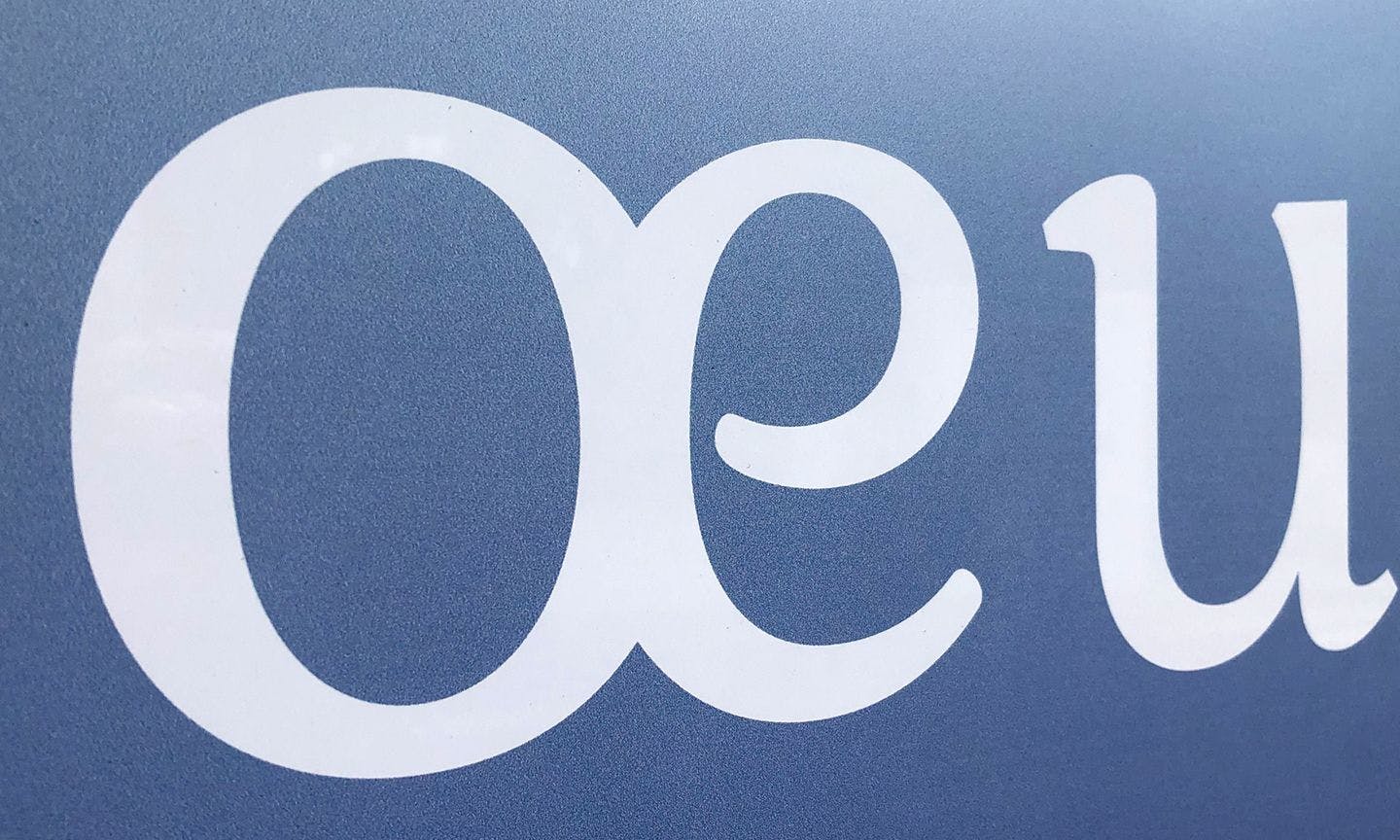 primer plano del detalle de la tipografía blanca "œ" sobre un fondo azul degradado