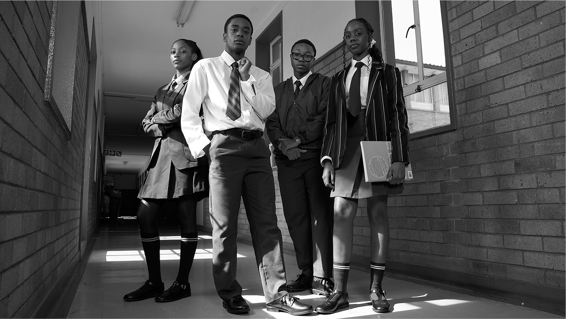 A group of students stand in a hallway at a school