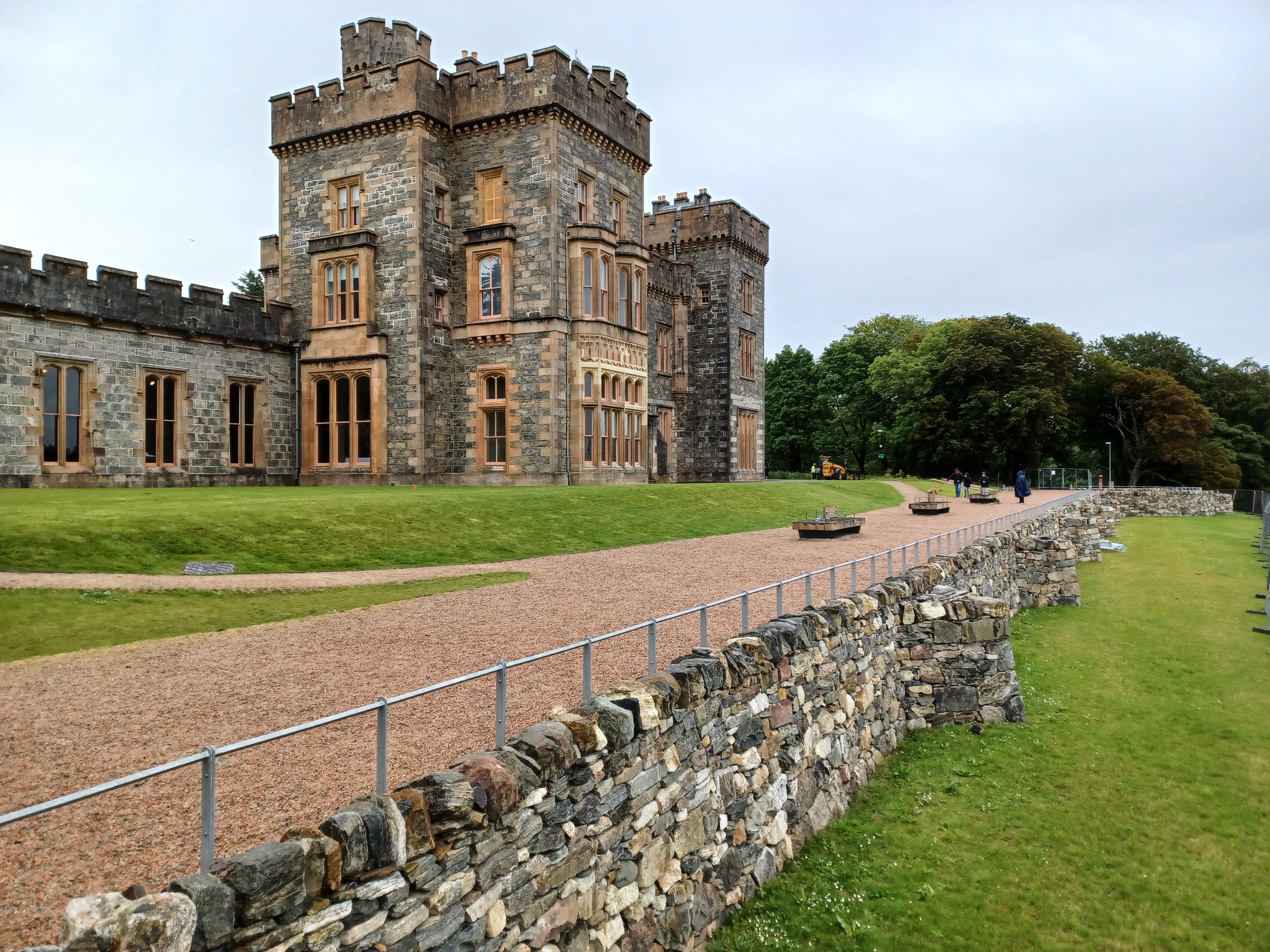Castle in rural area with path in front and a stone wall
