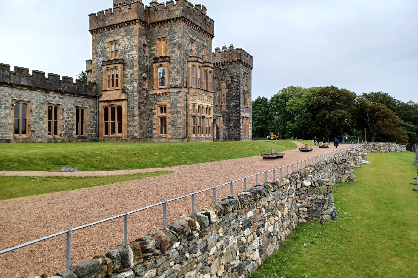 Castle in rural area with path in front and a stone wall