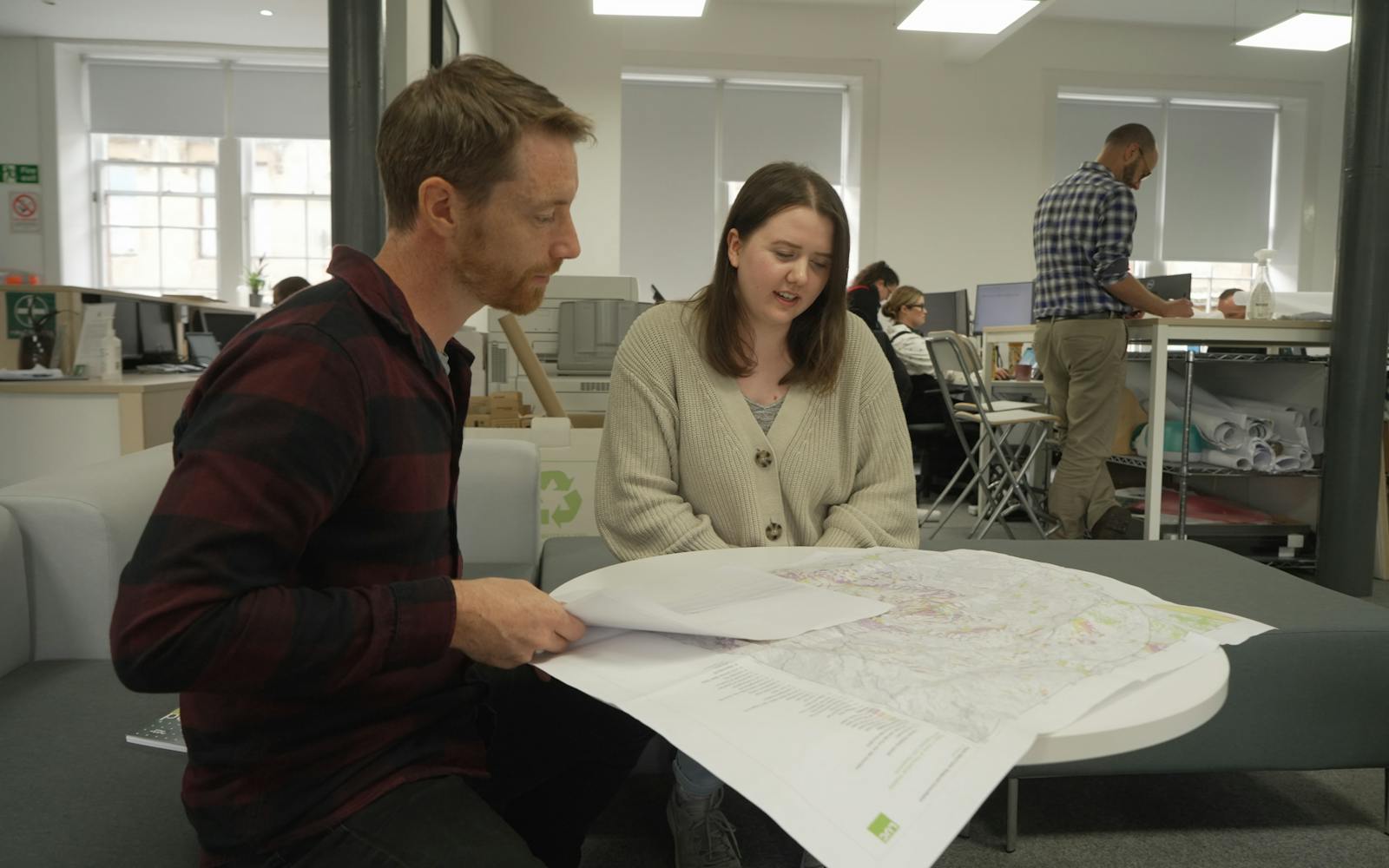 Two people working on a map in an office