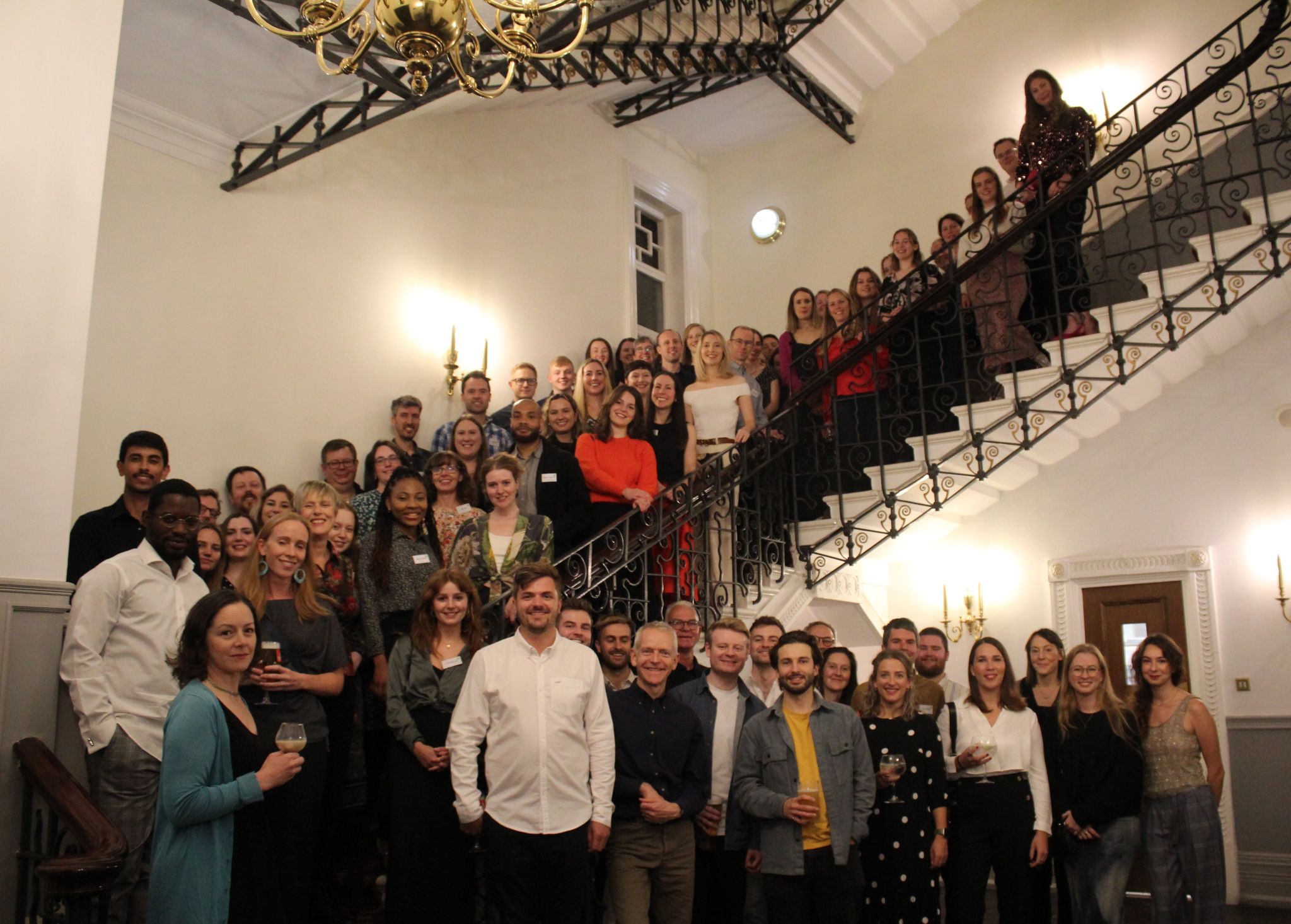 Large group of people smiling at camera on staircase