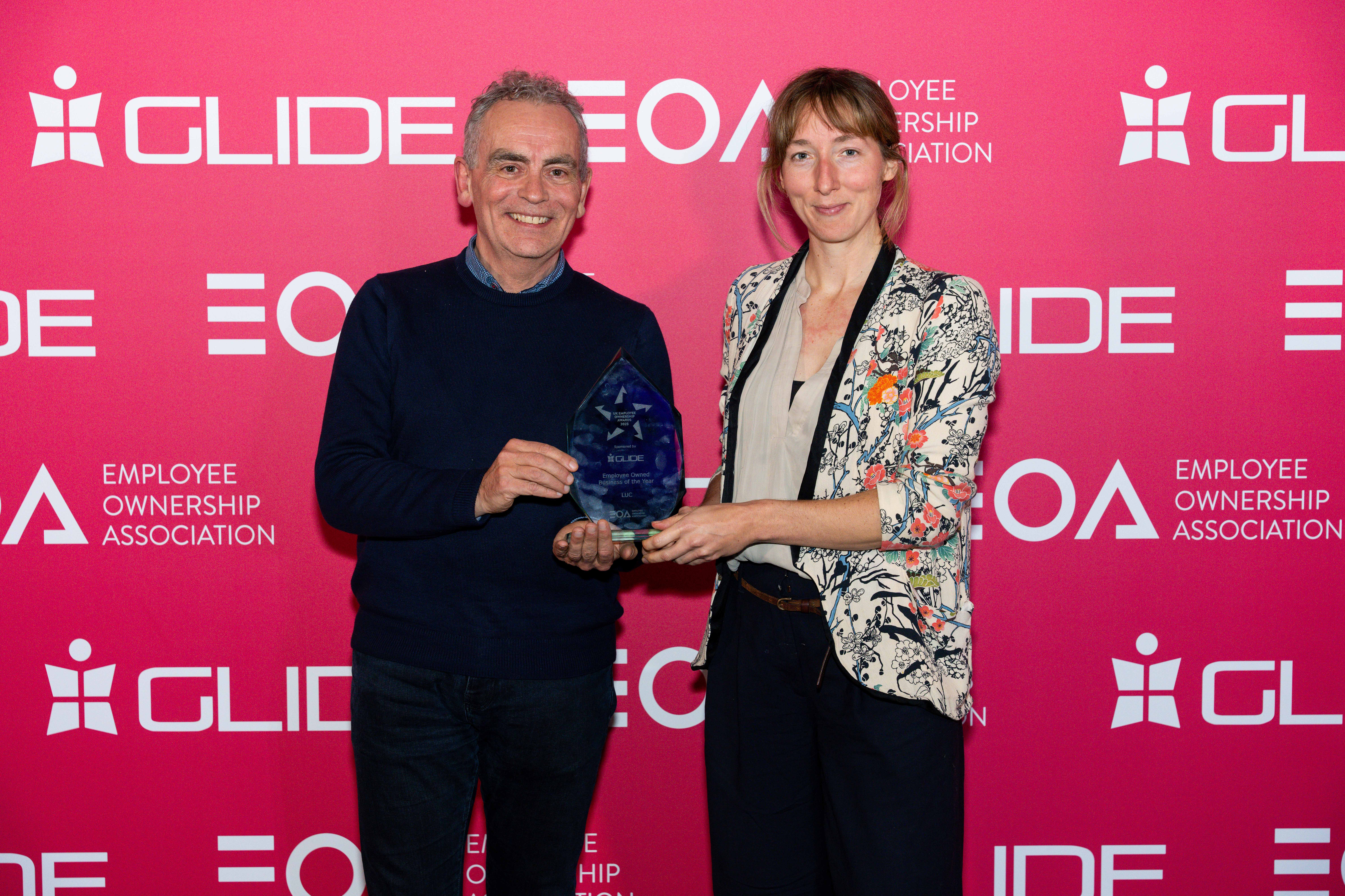 Two people holding a trophy