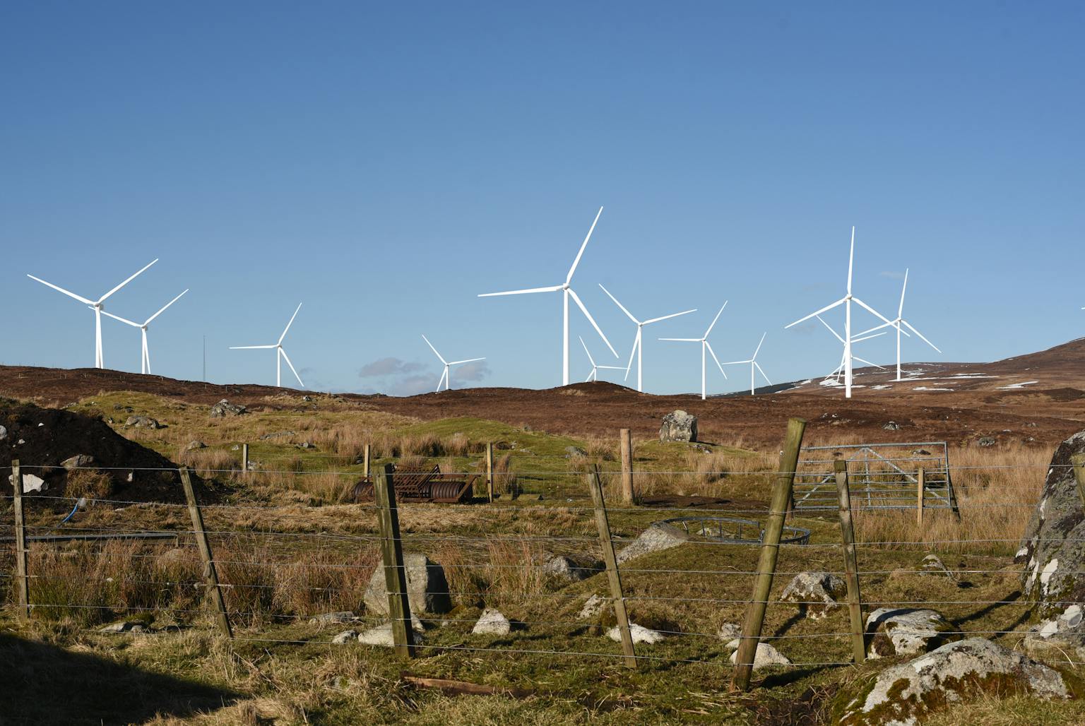 Wind farm on hill with blue sky