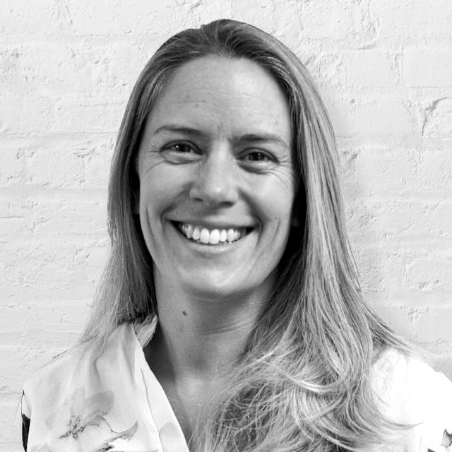 Person smiling in front of brick wall