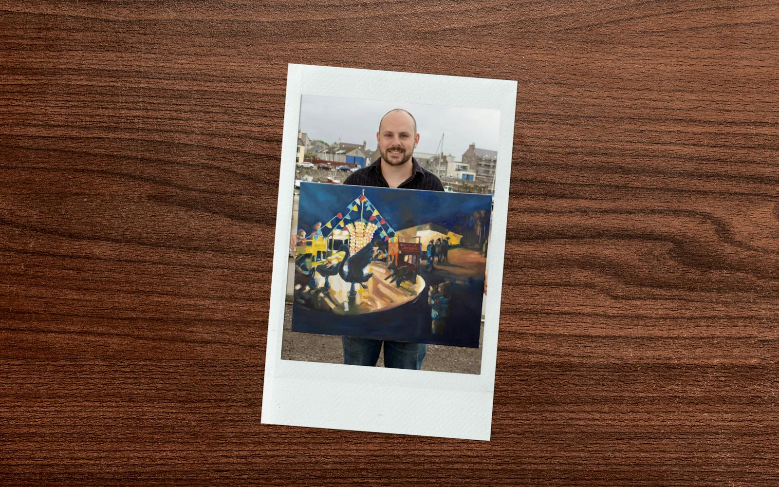 A man proudly displaying a painting, showcasing vibrant colors and intricate details.