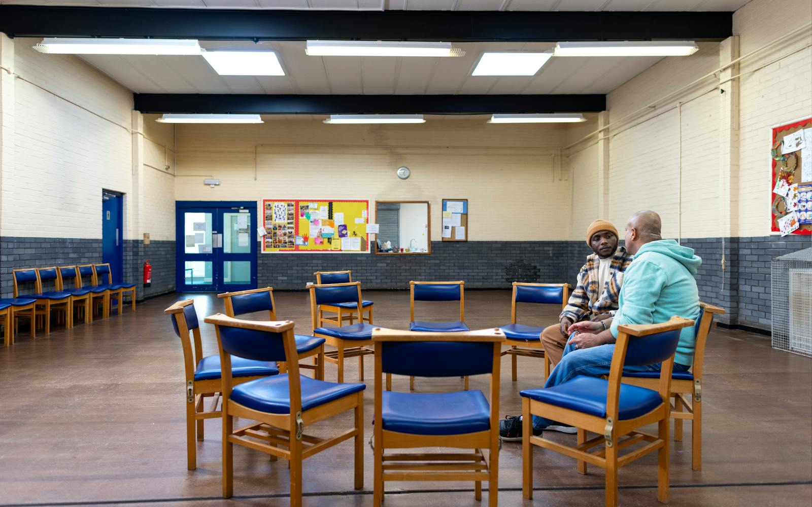 A room with chairs arranged neatly for a meeting. The chairs are empty, waiting for people to sit and engage in discussions.