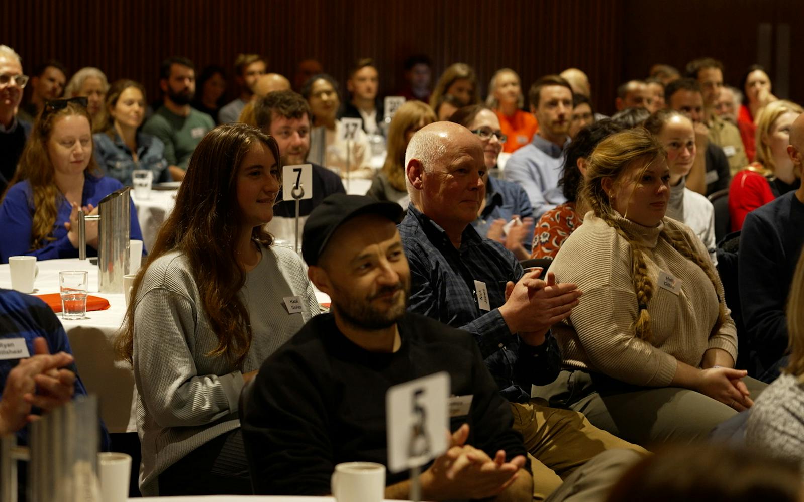 A room of people sat down and clapping