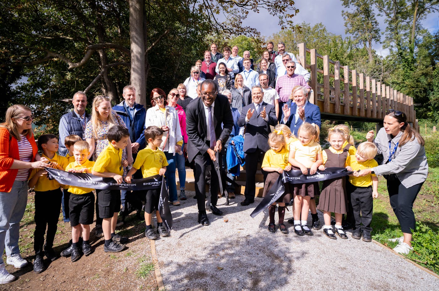 Group of people with school children cutting a ribbon