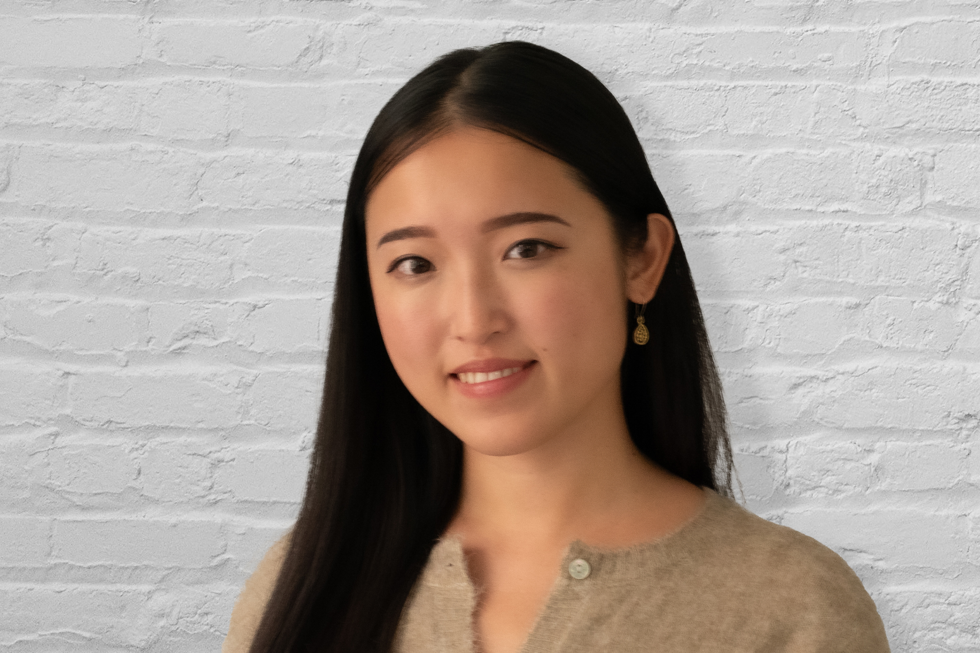 Person standing in front of brick wall