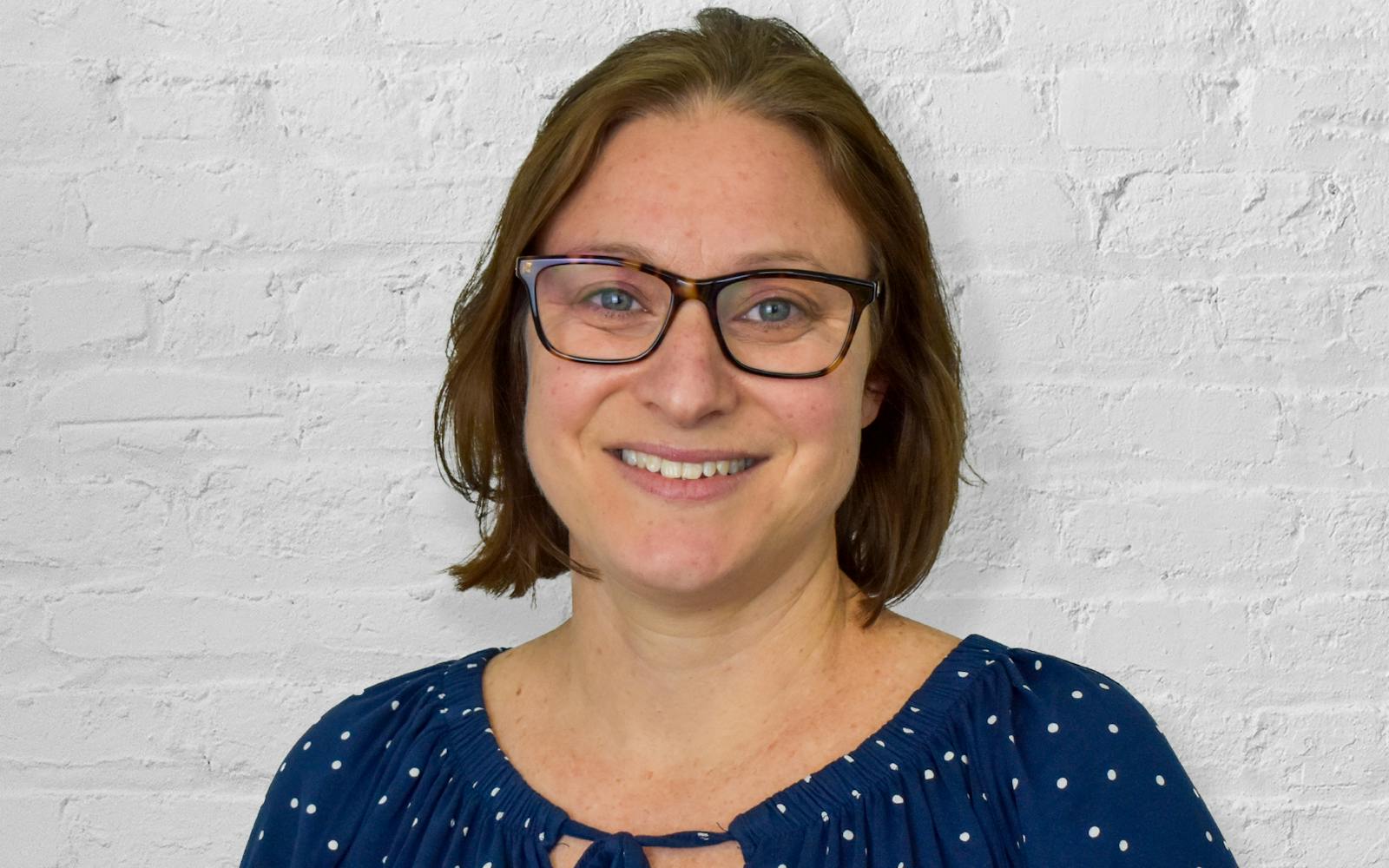 Person in front of white brick wall