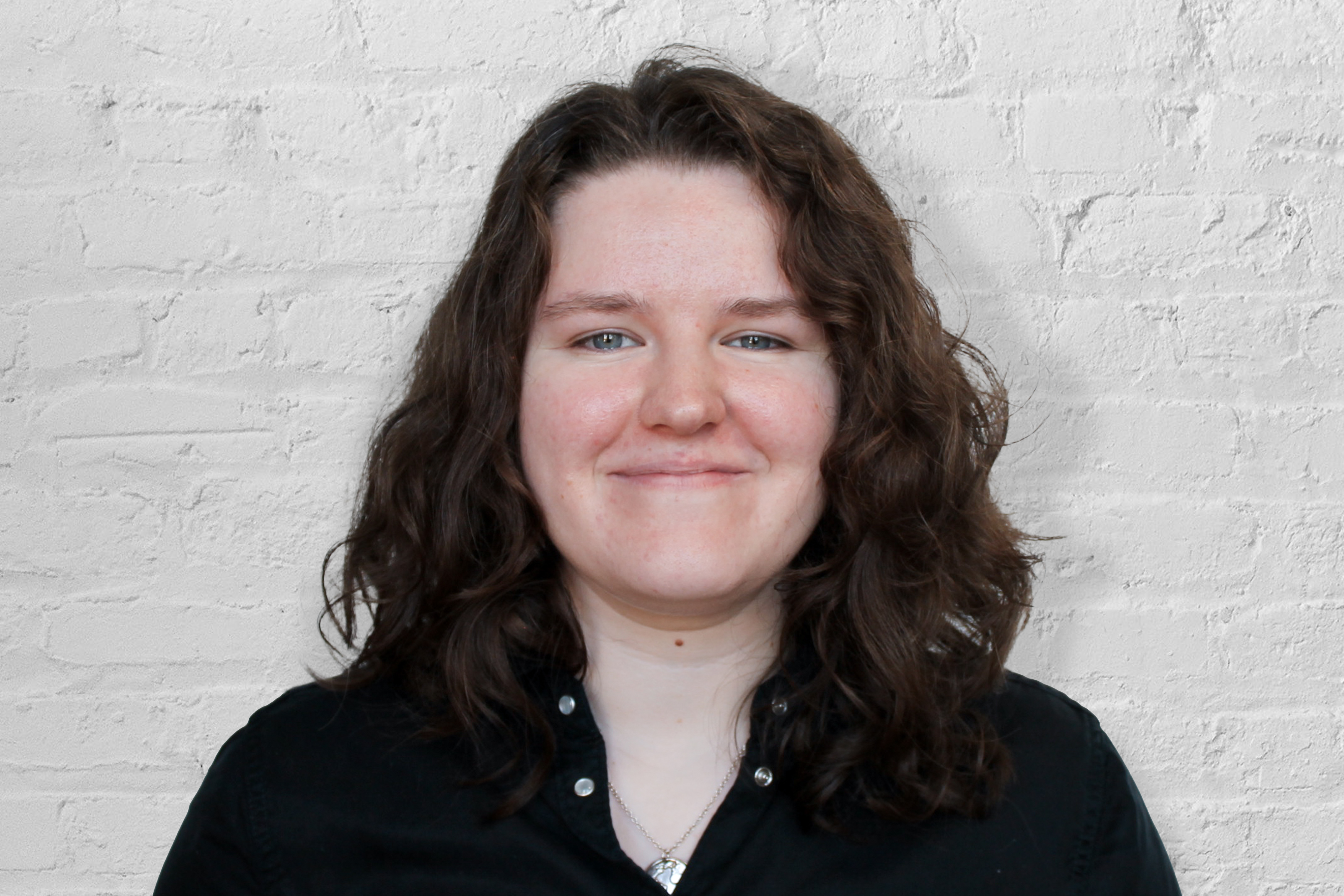 A person in front of a brick wall