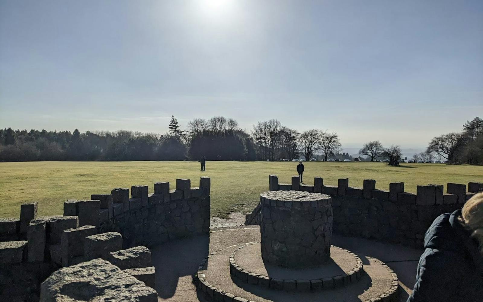 A castle-like structure with a field in the background and blue skies
