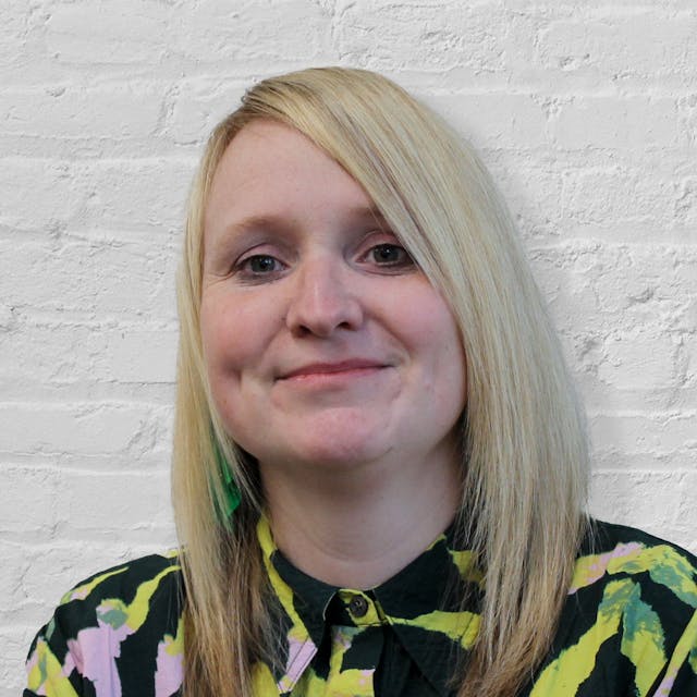 A person in front of a brick wall