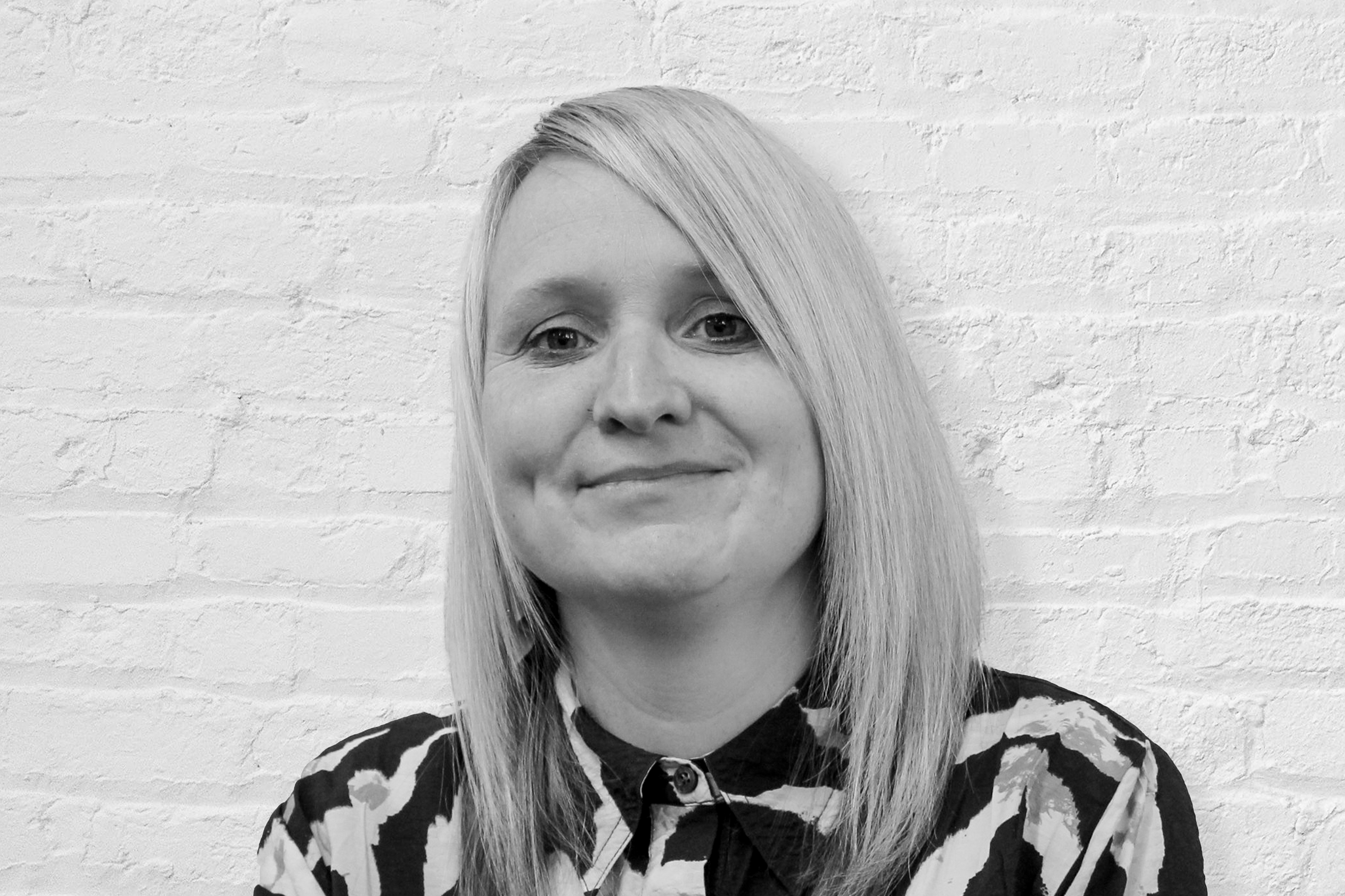 A person in front of a brick wall