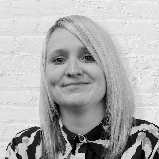 A person in front of a brick wall