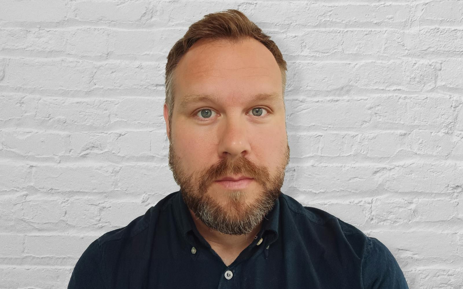 James Jarrett in front of a white brick wall