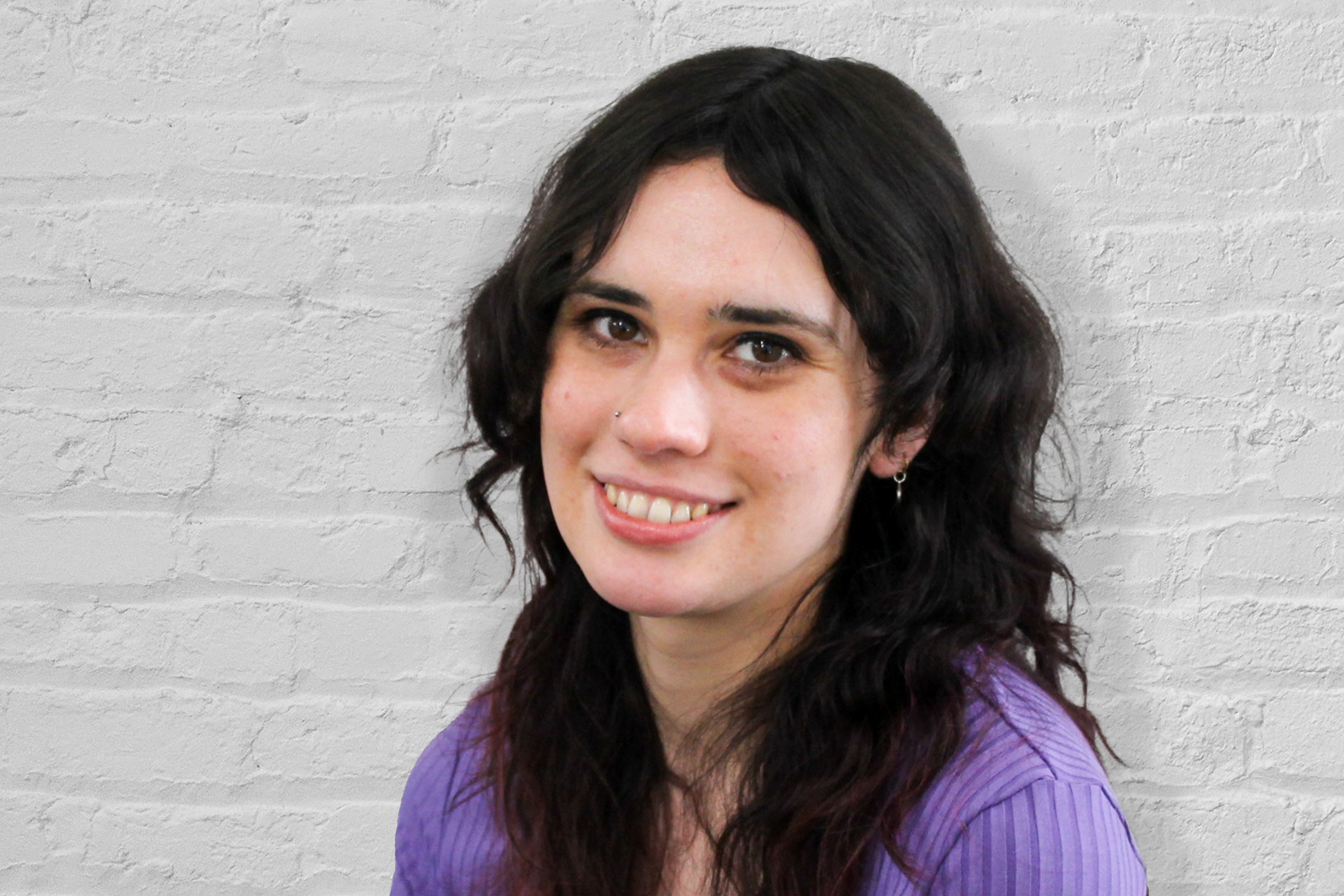 A person in front of a brick wall