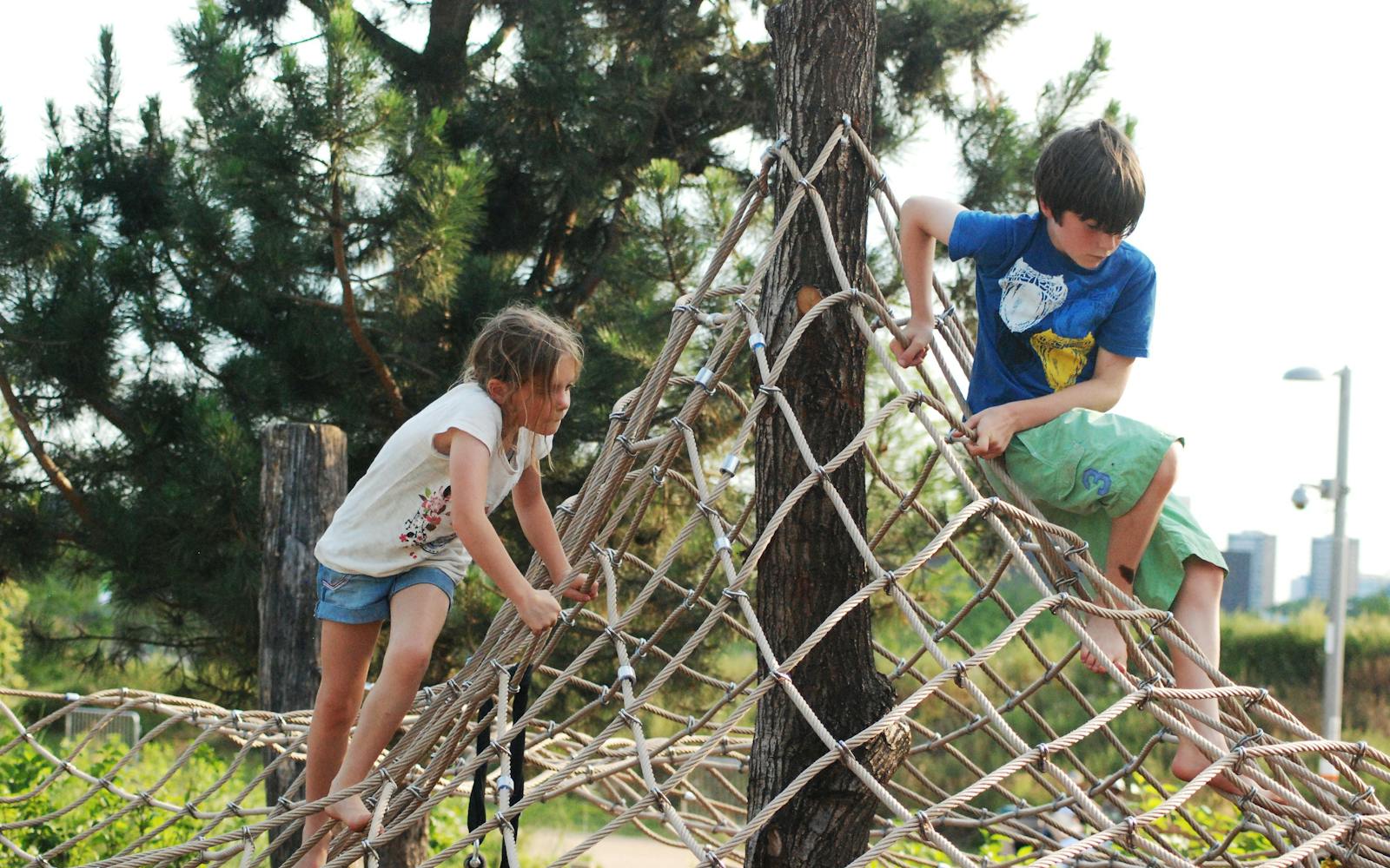 Children playing on a rope structure in a playground