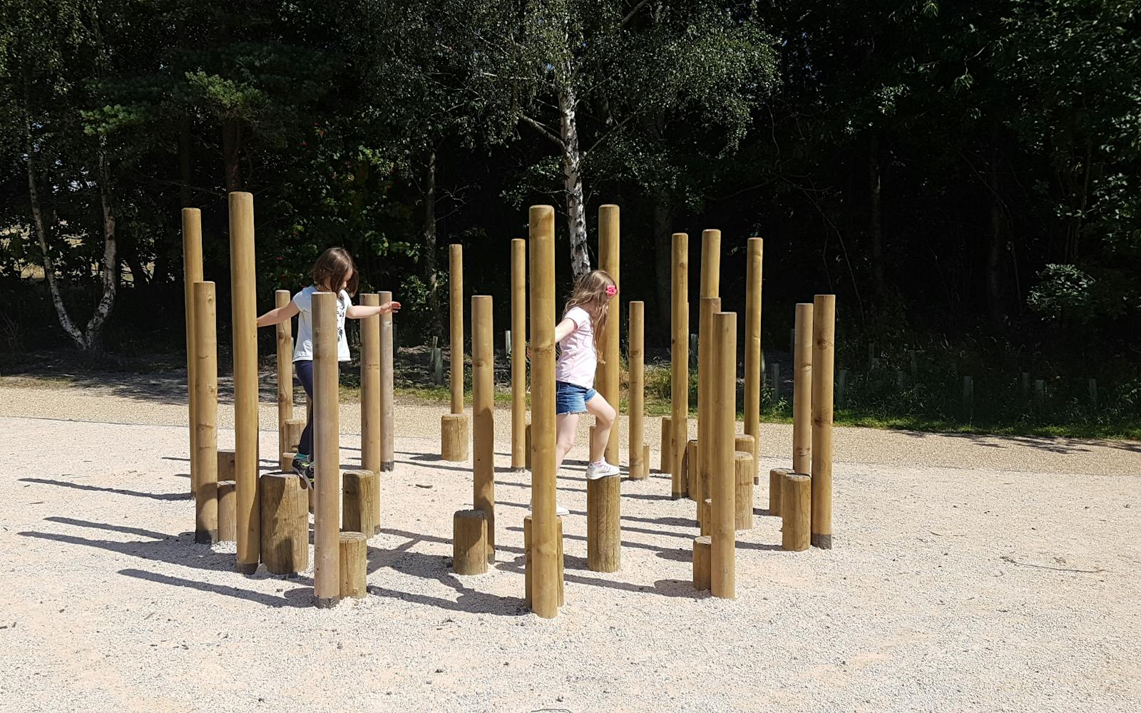 Children playing on a wooden structure in a playground