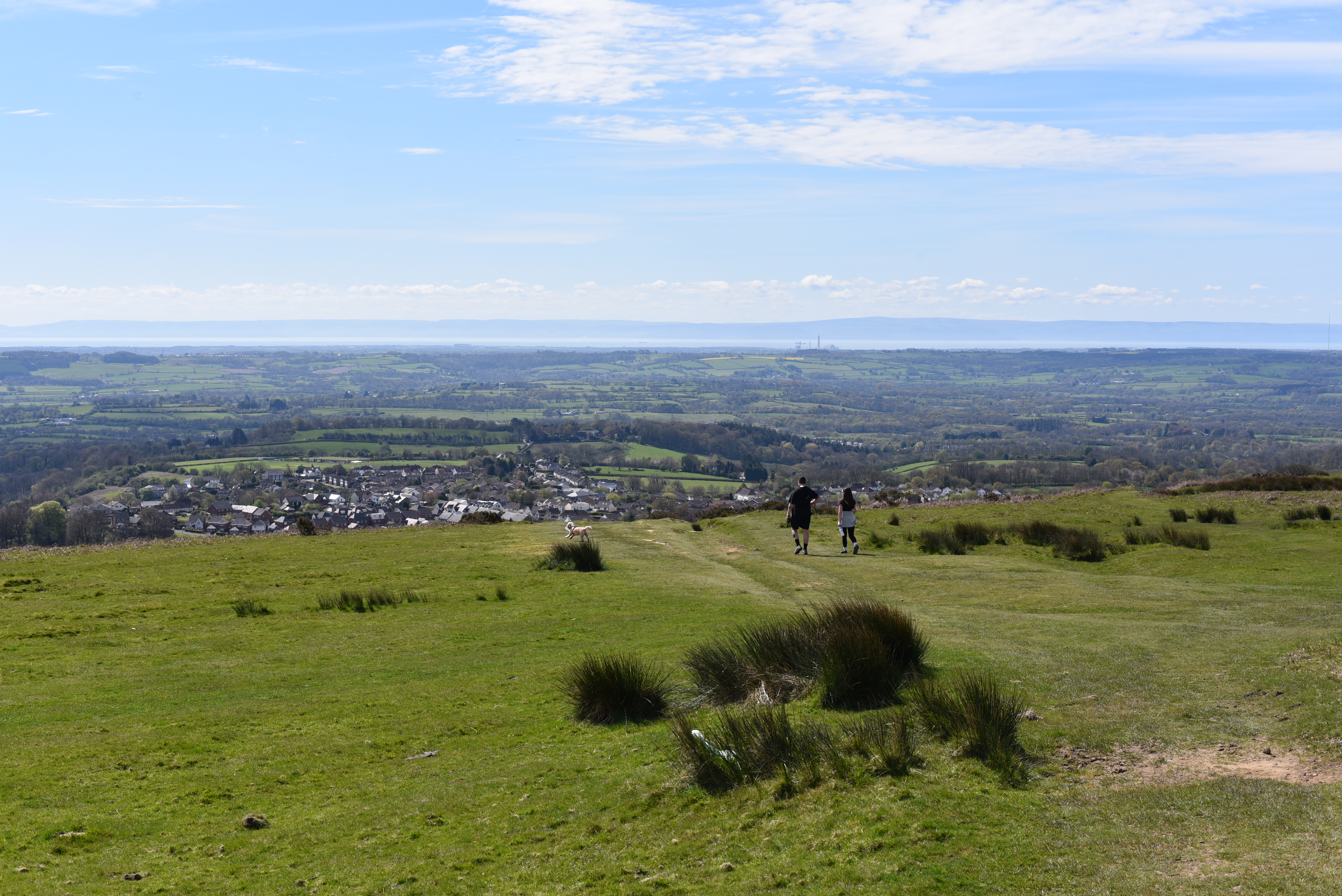 Hikers on a hilltop overlooking a valley.