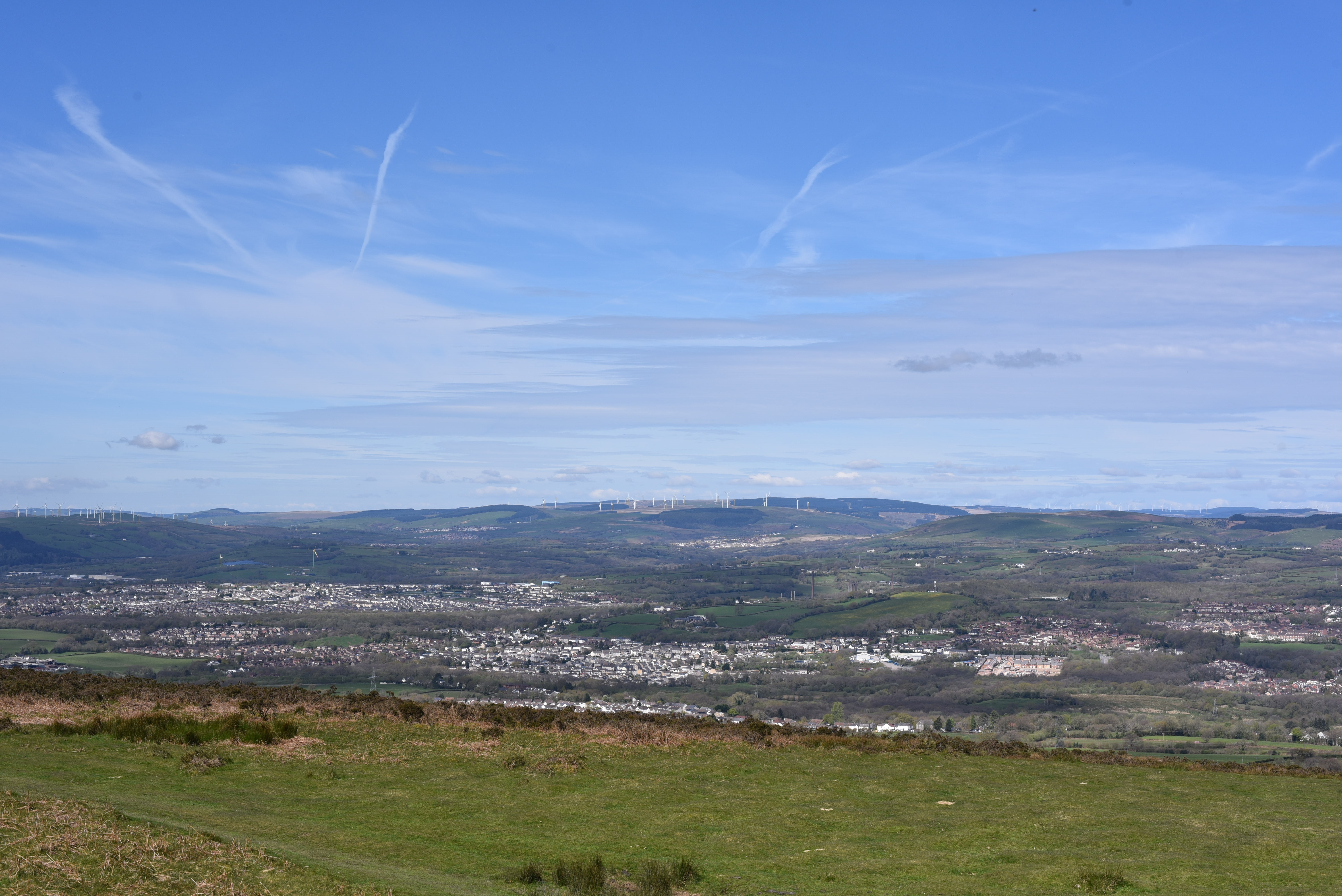 Scenic valley landscape with distant wind farm.