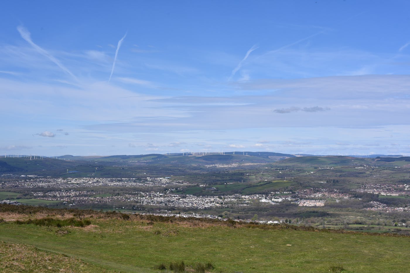 Scenic valley landscape with distant wind farm.