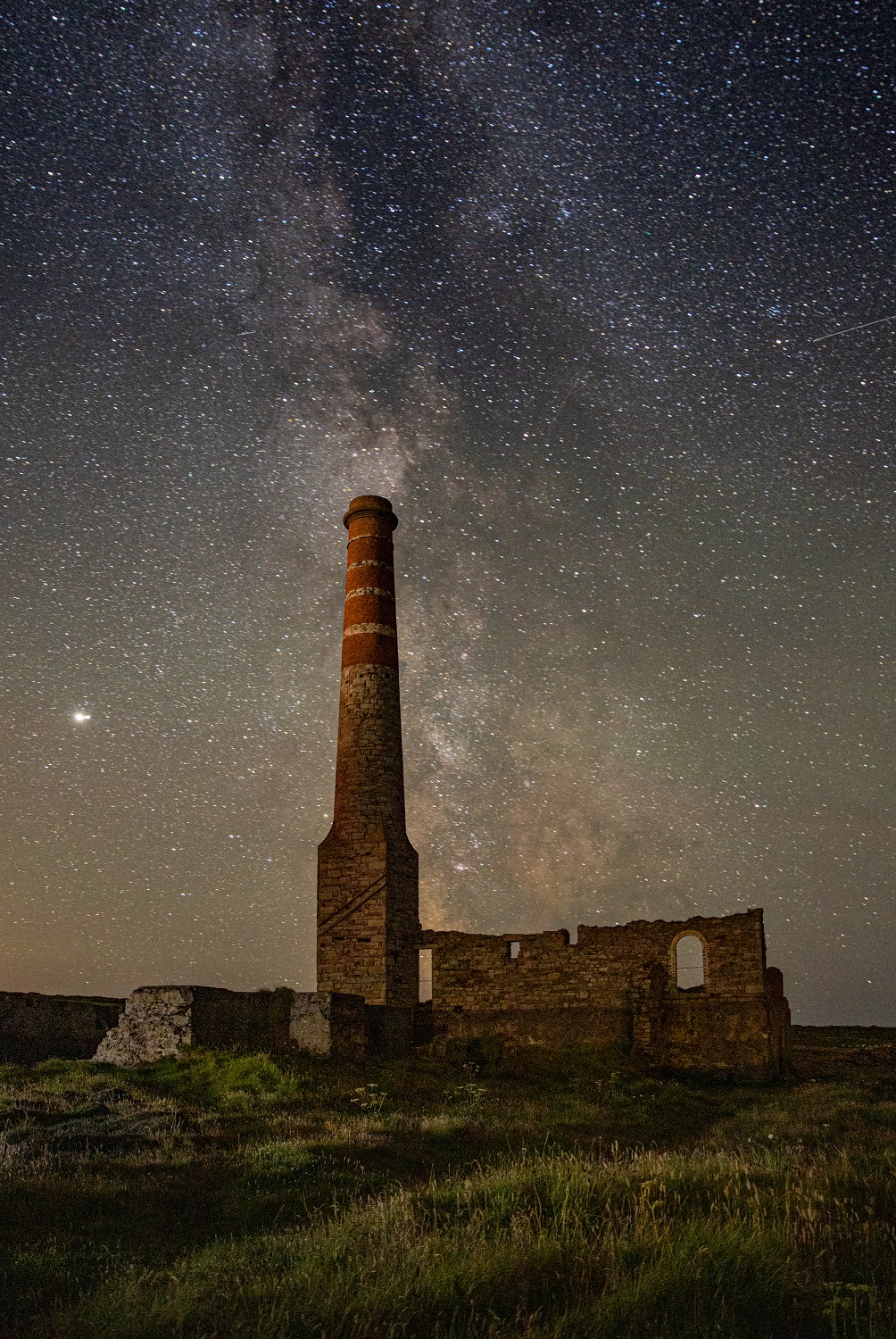 a brick tower and ruins under a starry sky
