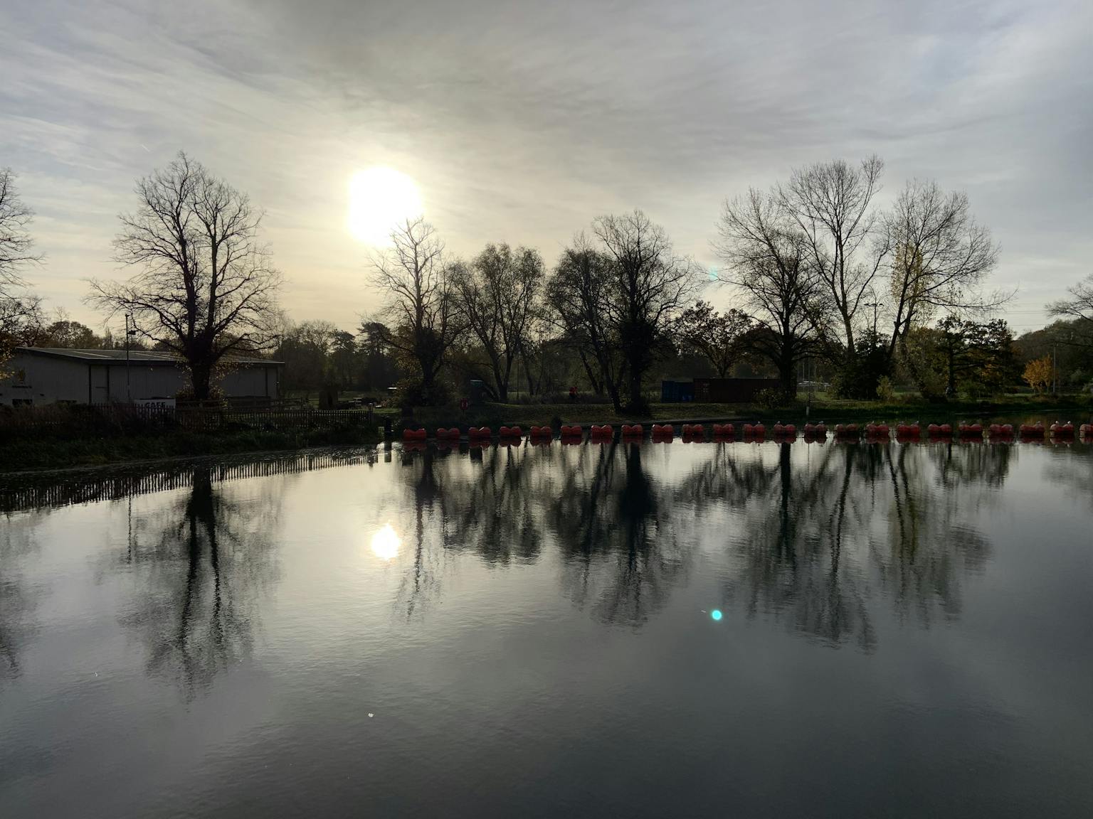 a body of water with trees and a cloudy sky