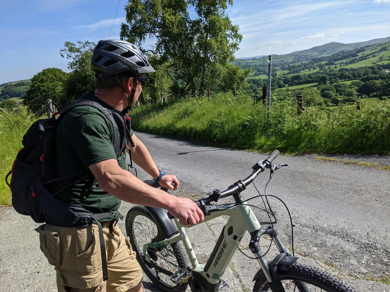 a man with a helmet and a bicycle on a road