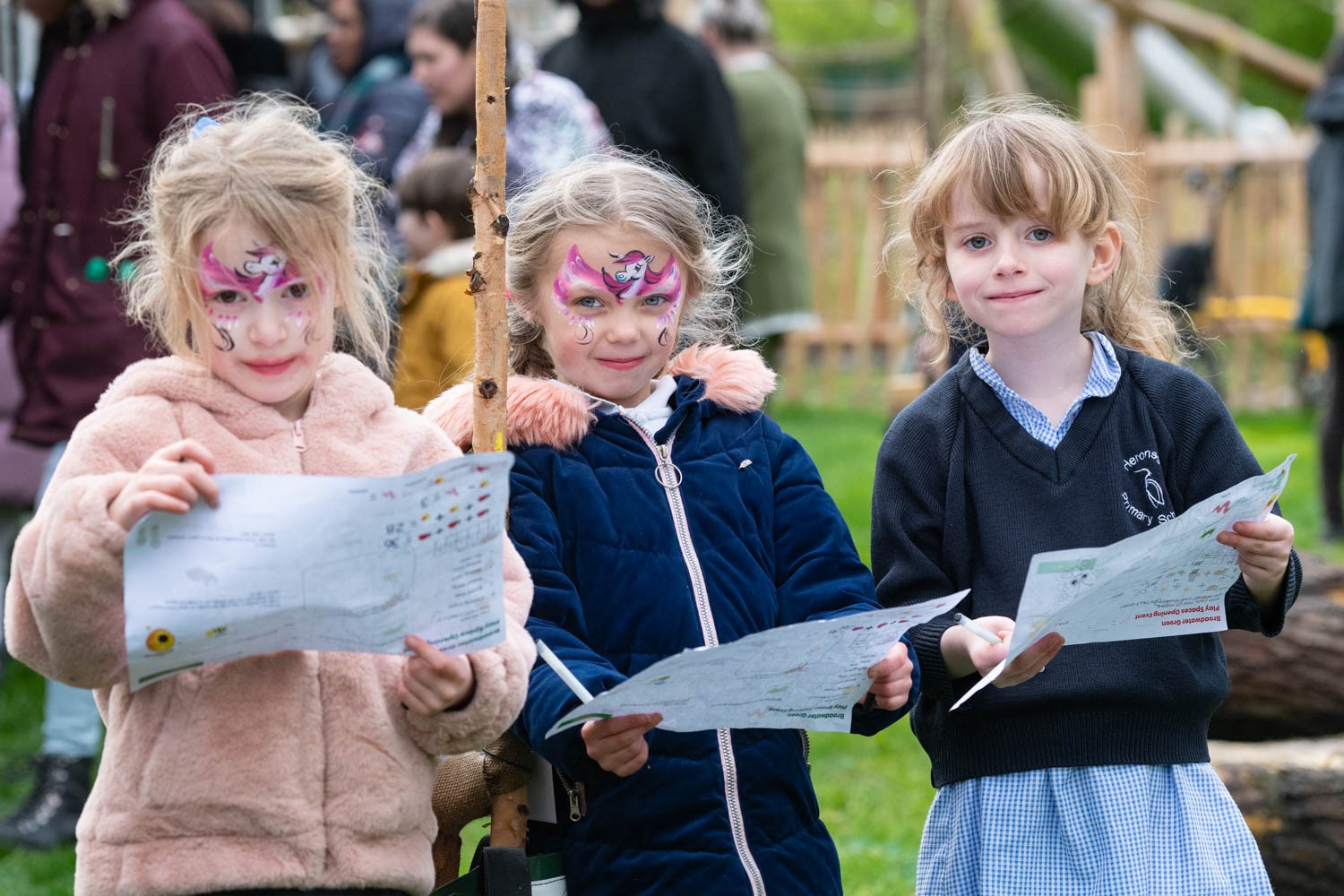 a group of girls with face paint holding papers