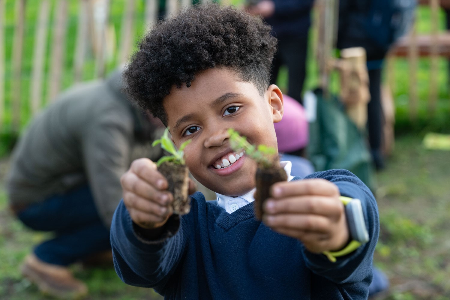 a boy holding small plants