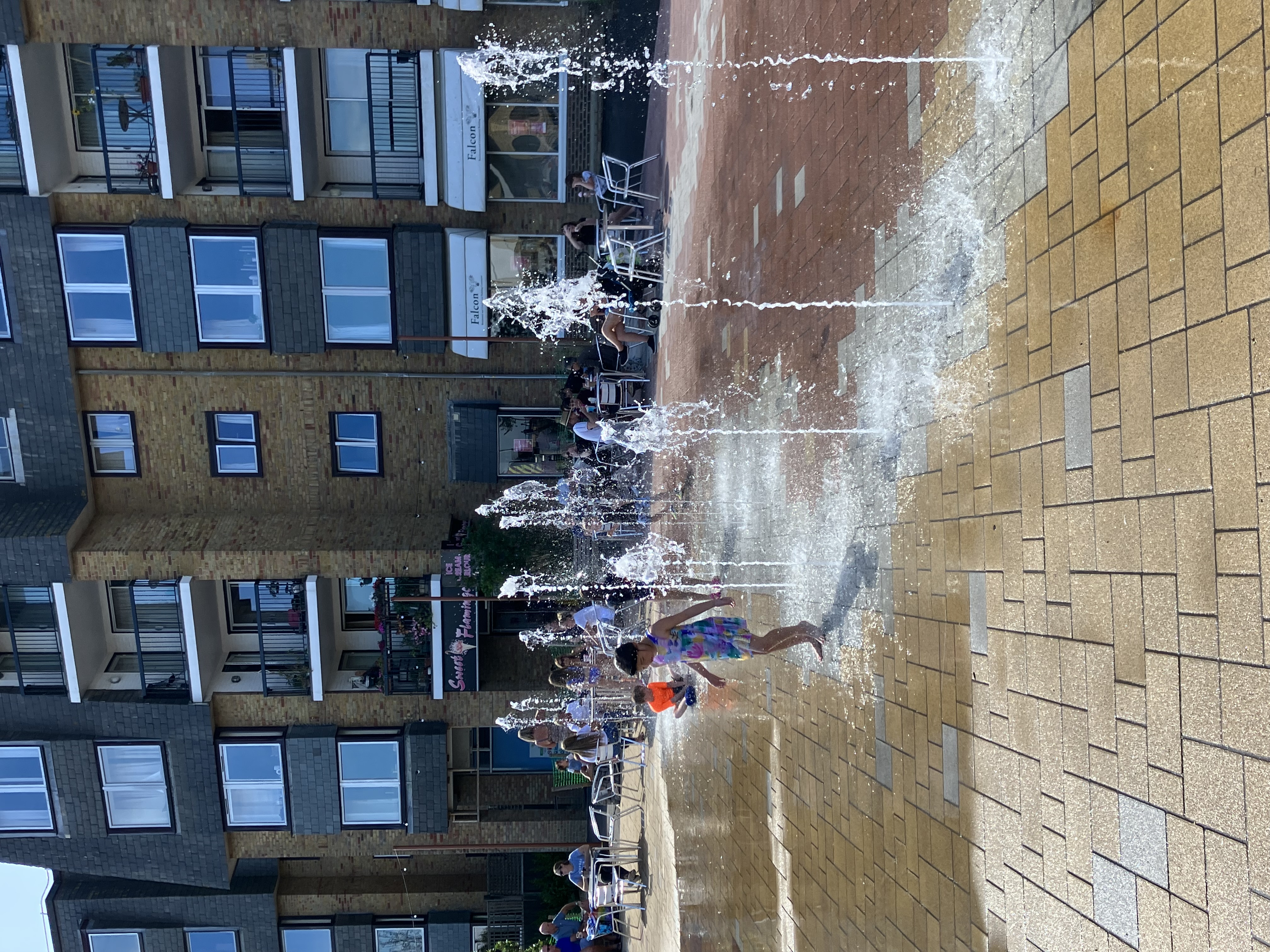 a group of kids playing in a water fountain