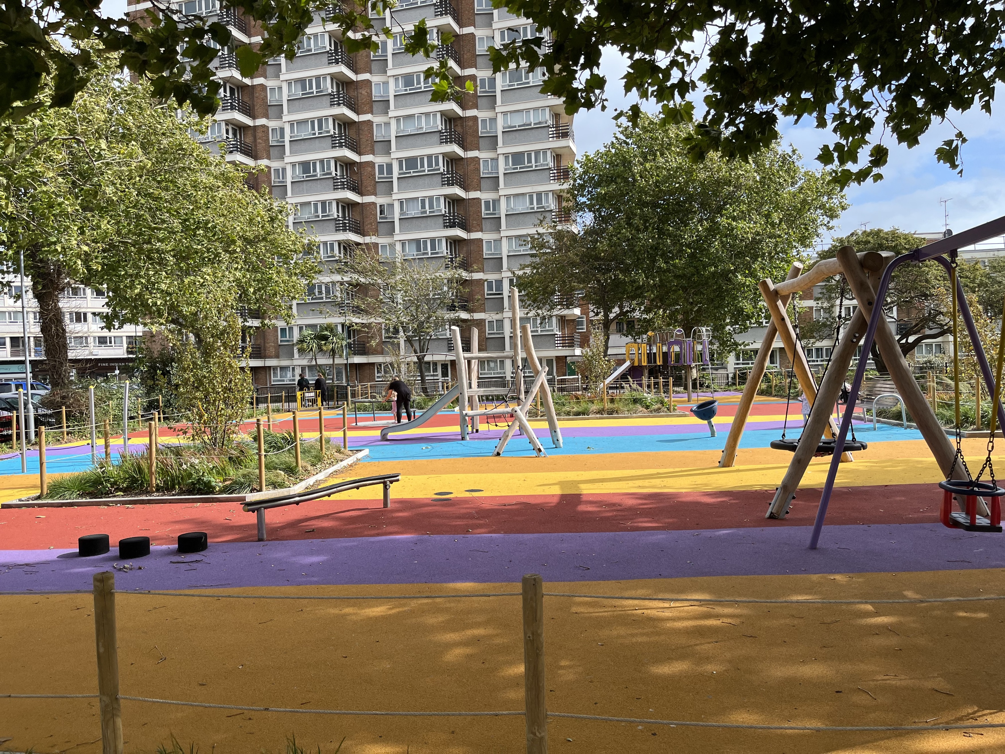 a playground with a large building in the background