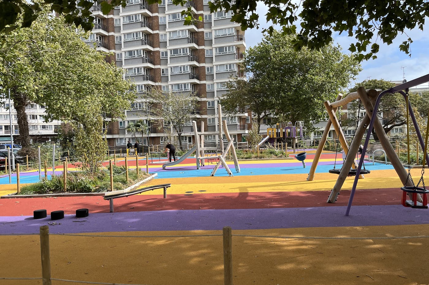 a playground with a large building in the background