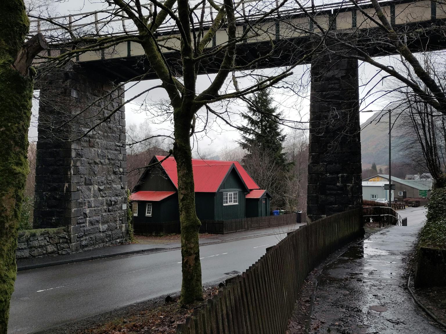 a house with a red roof under a bridge