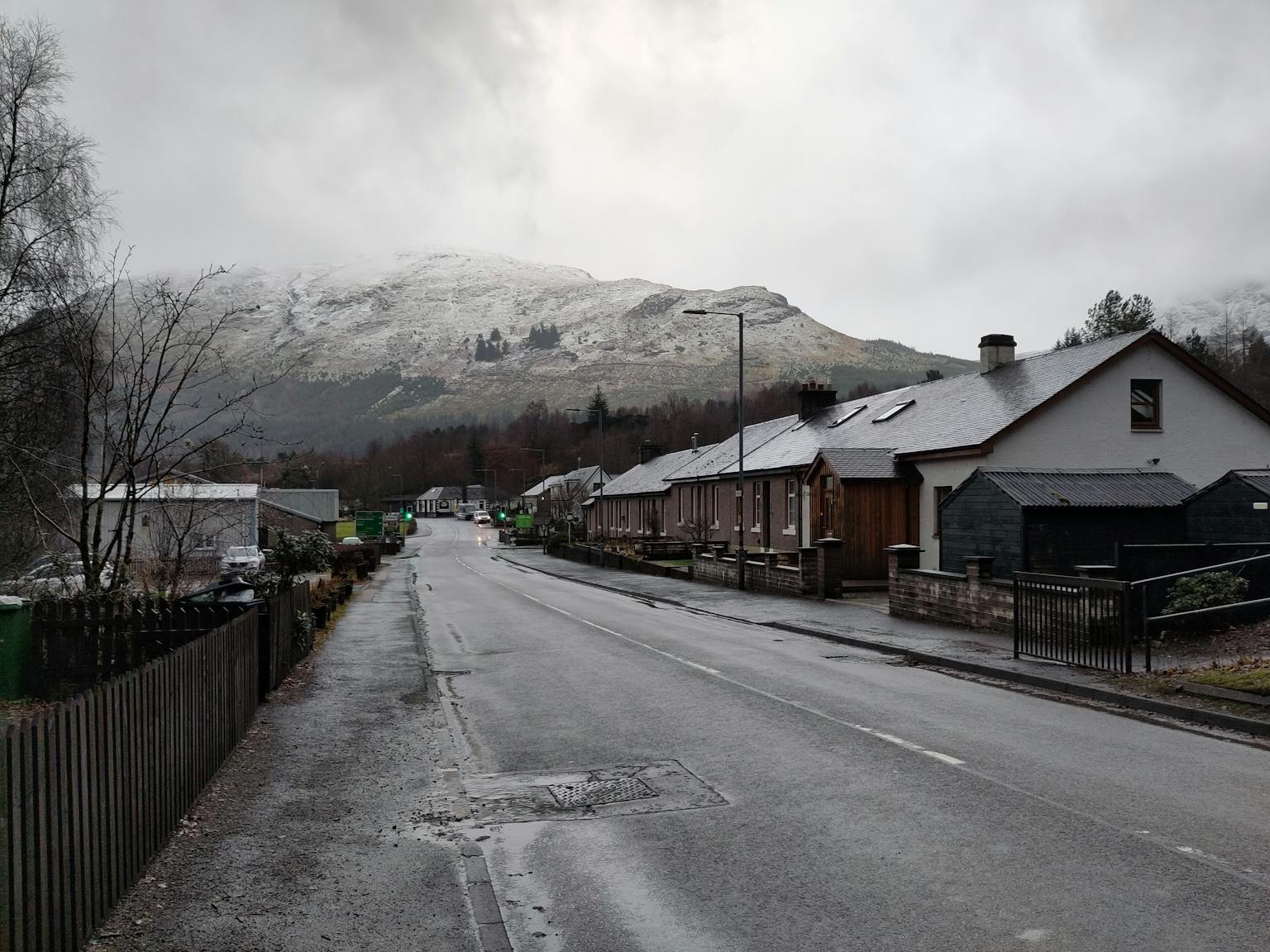 a street with houses and a snowy mountain in the background