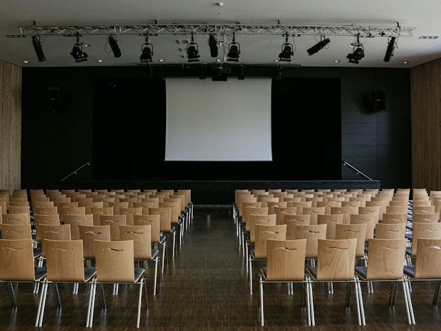 a room with chairs and a projector screen