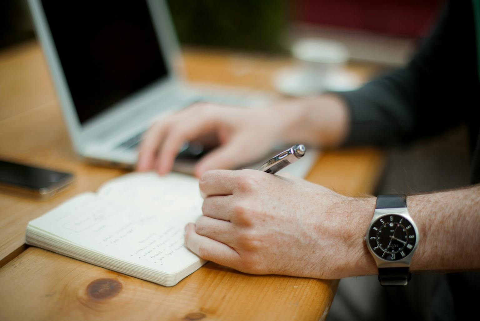 a person writing on a notebook