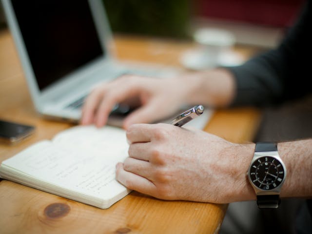 a person writing on a notebook