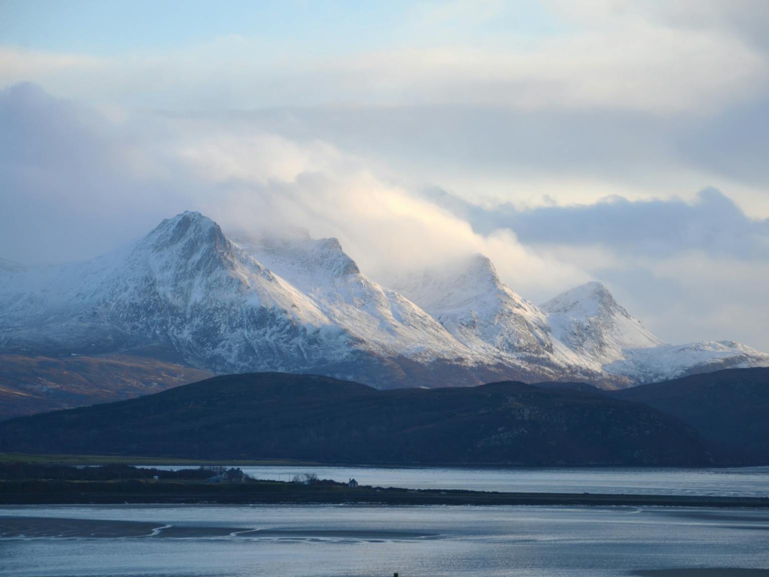 Snowy mountains next to water