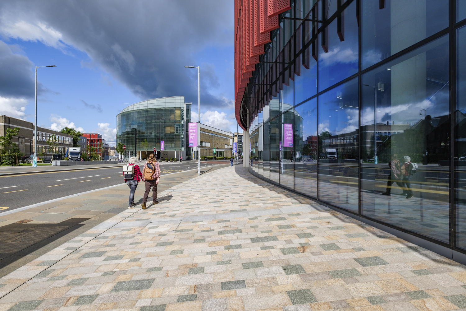 People walking on pavement in front of university building