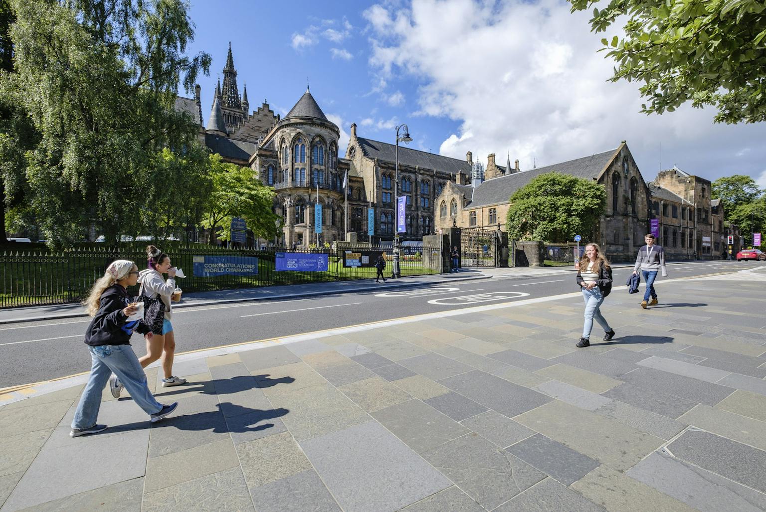 People walking on pavement in front of university building