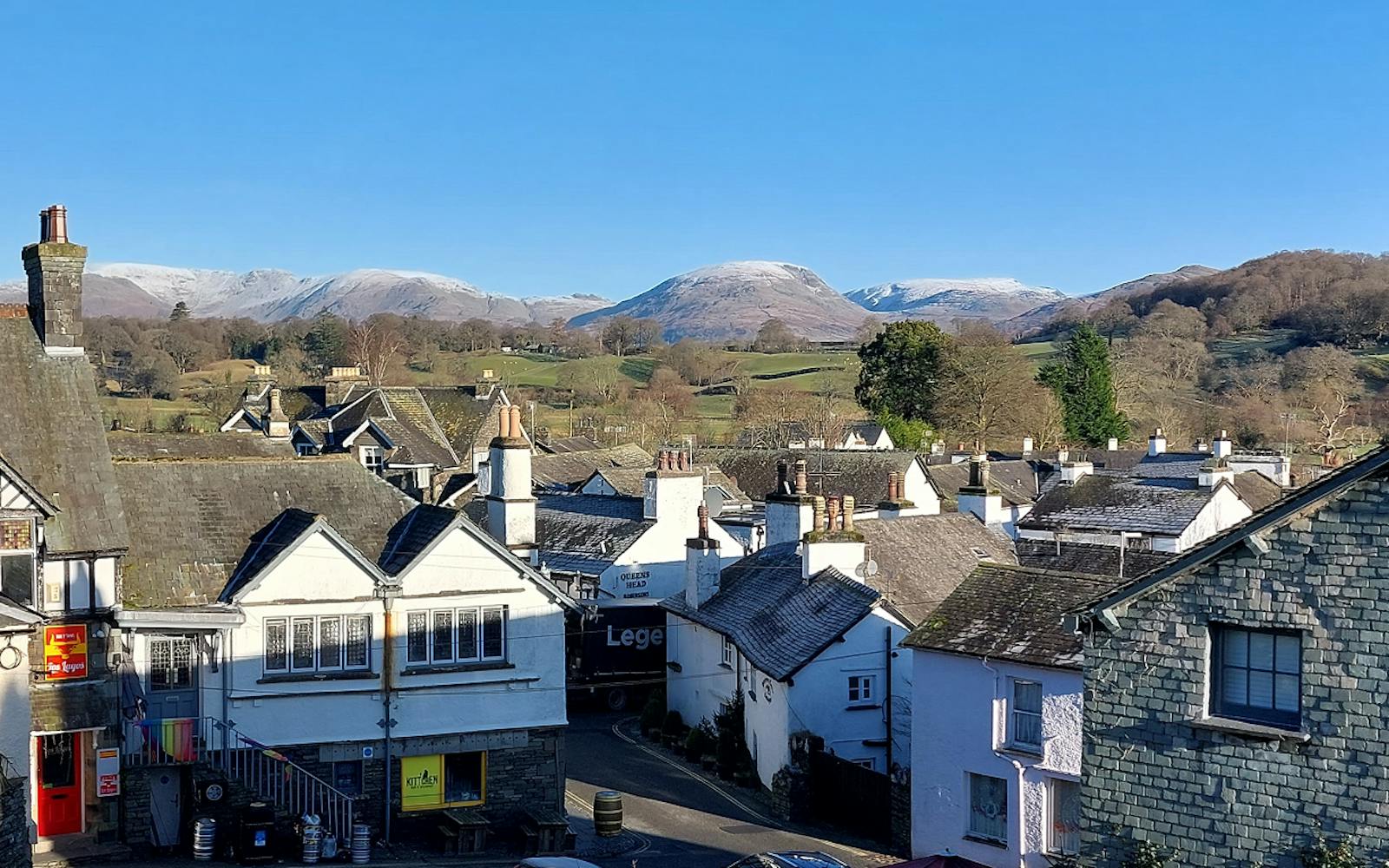 A countryside village with snowy hills in the background