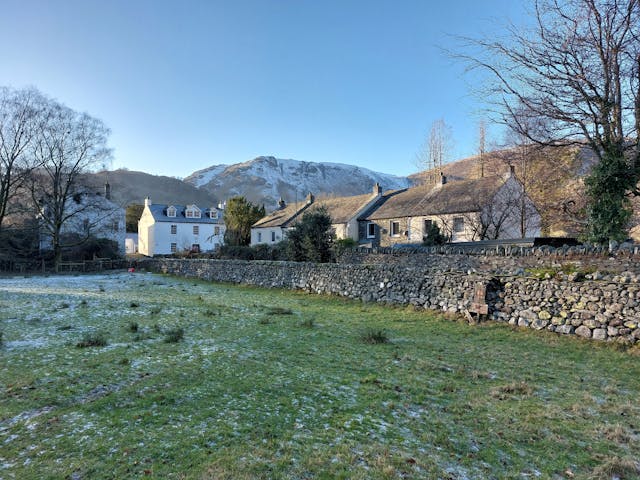 Some countryside cottages with snowy hills in the background