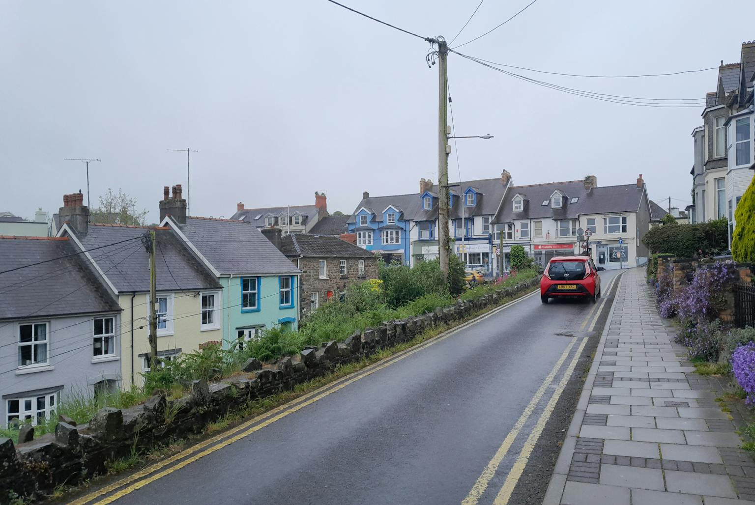 A car driving down a residential street lined with houses