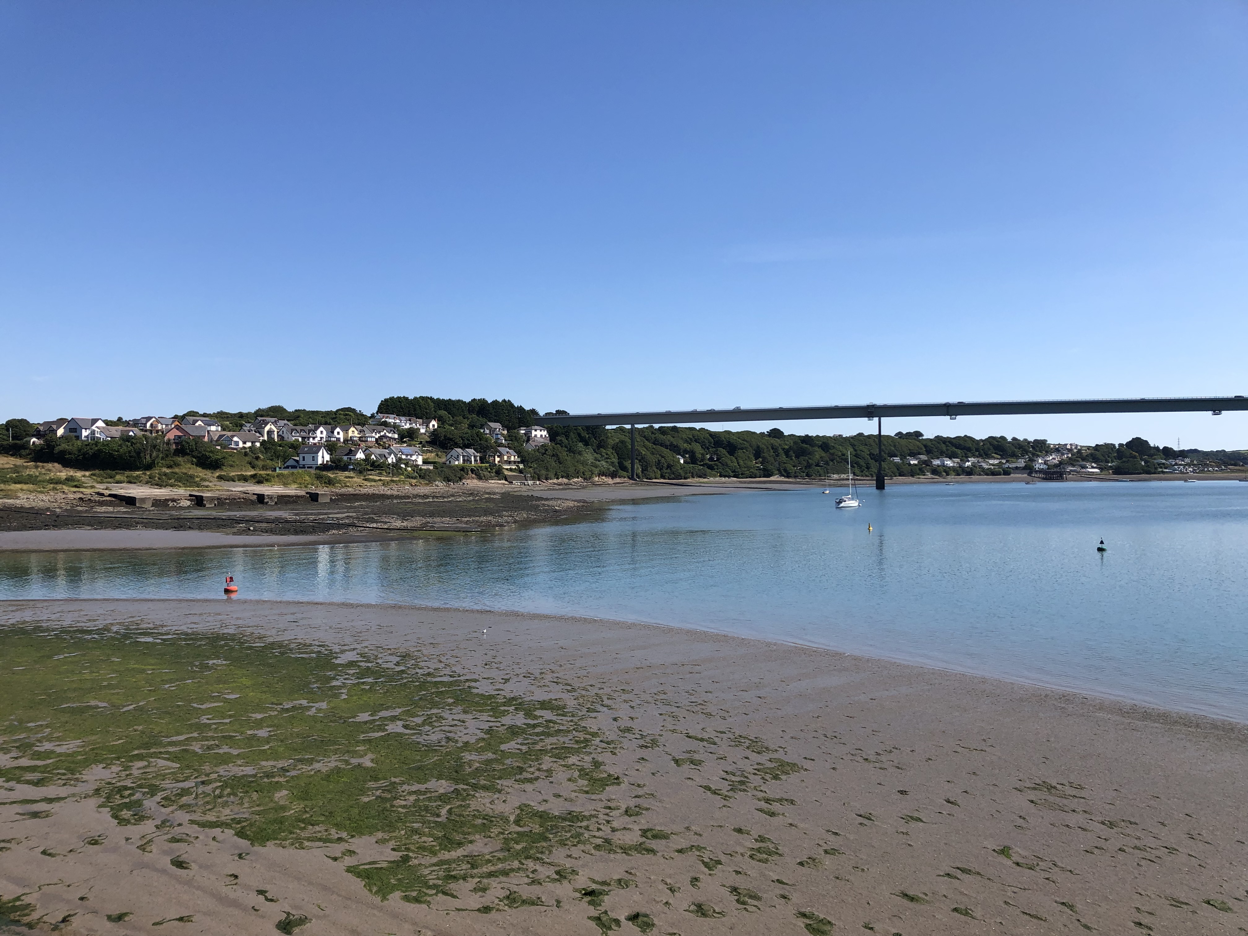 A body of water with a bridge in the background