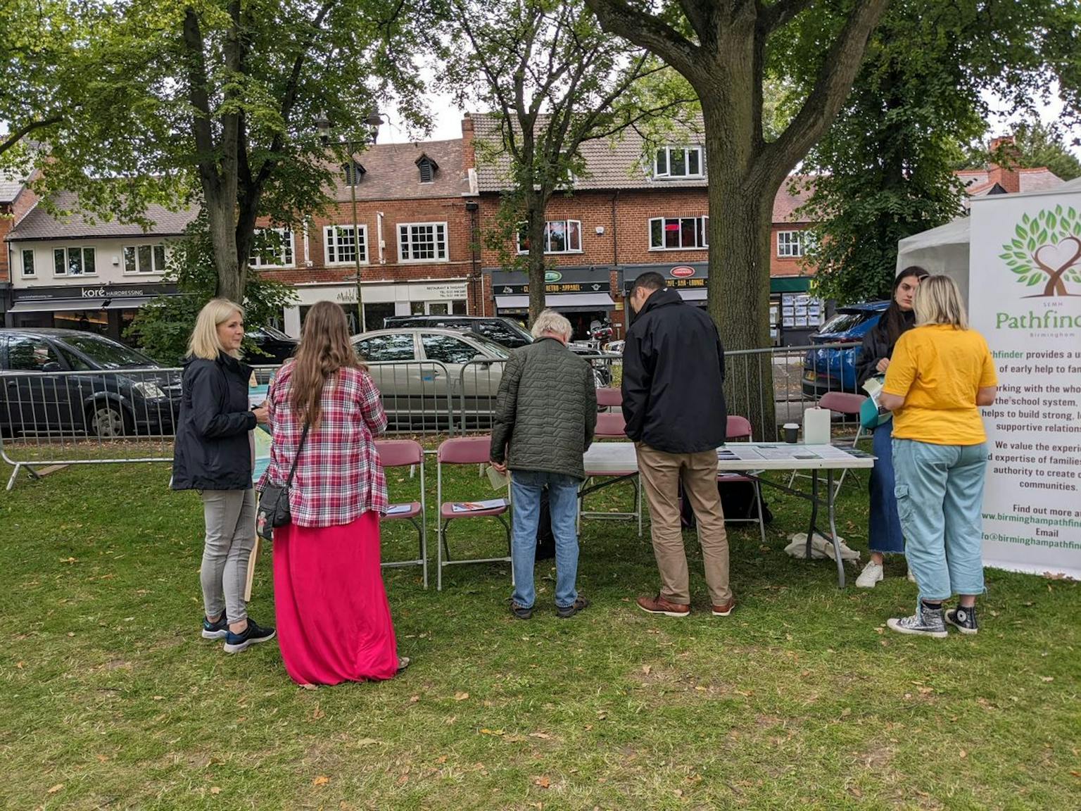 a group of people standing around tables and chairs