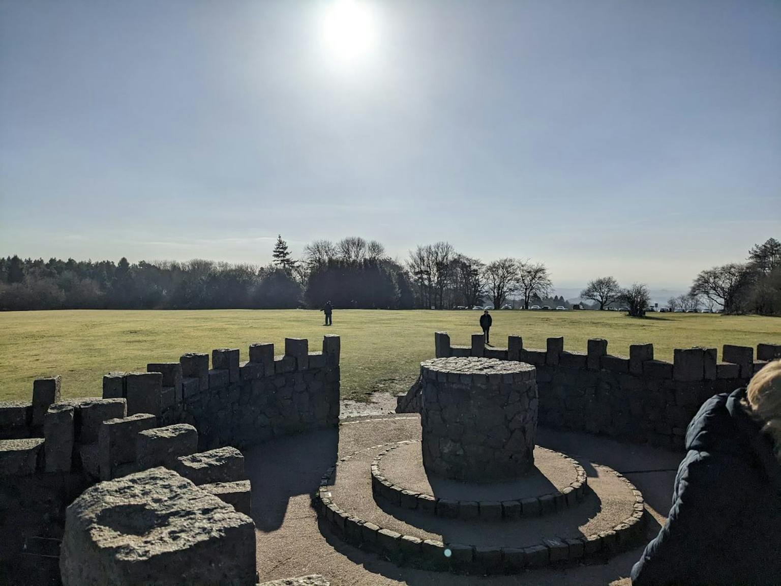 a stone structure in a grassy field